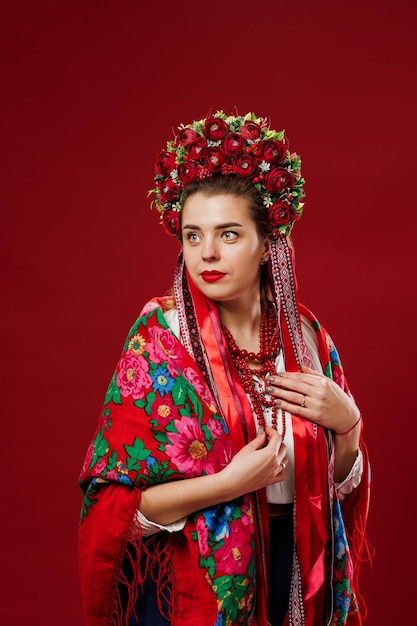 Retrato de mulher ucraniana em roupas étnicas tradicionais e guirlanda vermelha floral em fundo de estúdio viva magenta Vestido bordado nacional ucraniano chamado vyshyvanka Ore pela Ucrânia