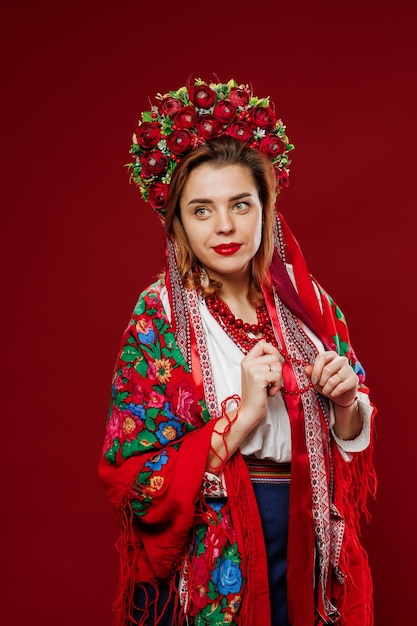 Retrato de mulher ucraniana em roupas étnicas tradicionais e guirlanda vermelha floral em fundo de estúdio viva magenta Vestido bordado nacional ucraniano chamado vyshyvanka Ore pela Ucrânia