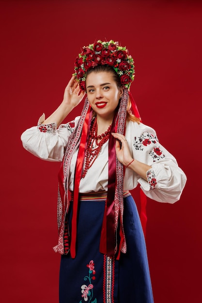 Retrato de mulher ucraniana em roupas étnicas tradicionais e guirlanda vermelha floral em fundo de estúdio viva magenta Vestido bordado nacional ucraniano chamado vyshyvanka Ore pela Ucrânia