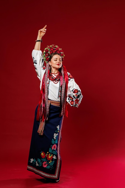 Retrato de mulher ucraniana em roupas étnicas tradicionais e guirlanda vermelha floral em fundo de estúdio viva magenta Vestido bordado nacional ucraniano chamado vyshyvanka Ore pela Ucrânia