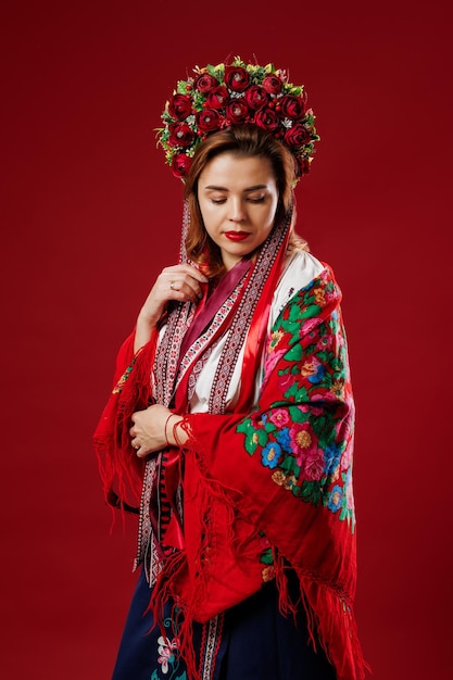 Retrato de mulher ucraniana em roupas étnicas tradicionais e guirlanda vermelha floral em fundo de estúdio viva magenta Vestido bordado nacional ucraniano chamado vyshyvanka Ore pela Ucrânia