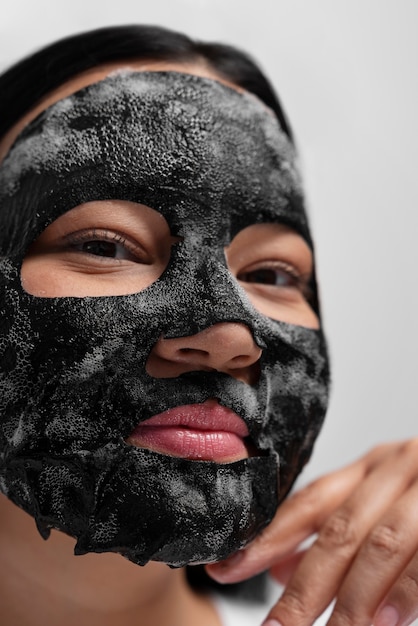 Foto retrato de mulher usando máscara facial de carvão