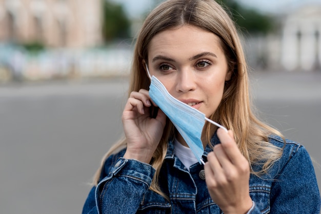 Foto retrato de mulher usando máscara médica ao ar livre