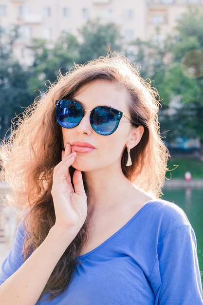 Retrato de mulher usando óculos de sol enquanto está de pé ao ar livre