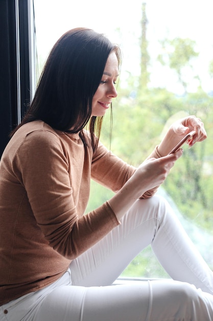 Retrato de mulher usando seu smartphone em casa