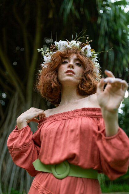 Retrato de mulher vestindo flores enquanto está de pé contra árvores