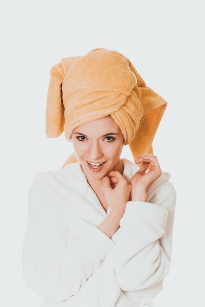 Foto retrato de mulher vestindo roupão de banho contra fundo branco