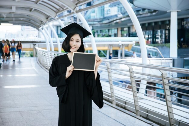 Retrato de mulher vestindo vestido de formatura enquanto está de pé na ponte