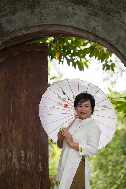 Retrato de mulher vietnamita em vestido Ao Dai ao ar livre