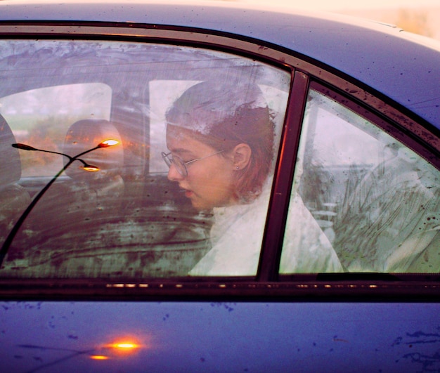 Foto retrato de mulher visto através da janela do carro