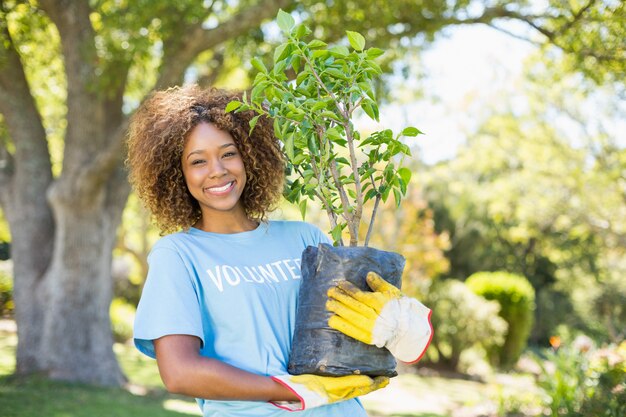 Retrato de mulher voluntária segurando a planta