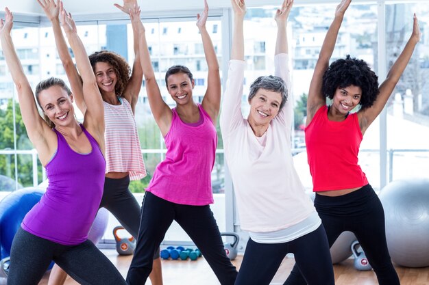 Retrato de mulheres felizes exercitando com braços levantados