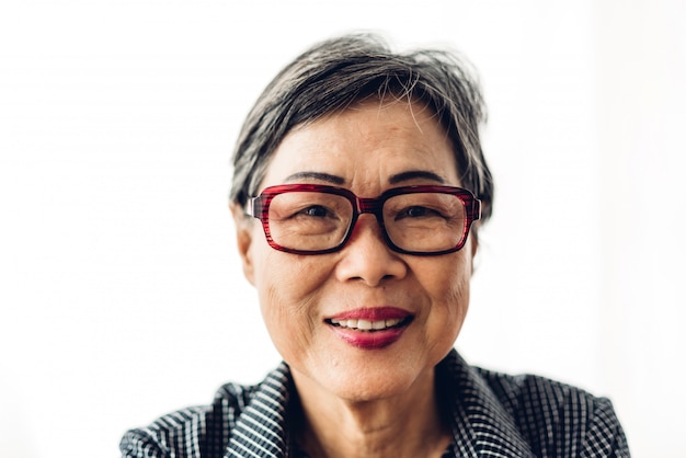 Retrato de mulheres idosas adultas sênior felizes da Ásia que sorriem e que olham a câmera no branco isolado.