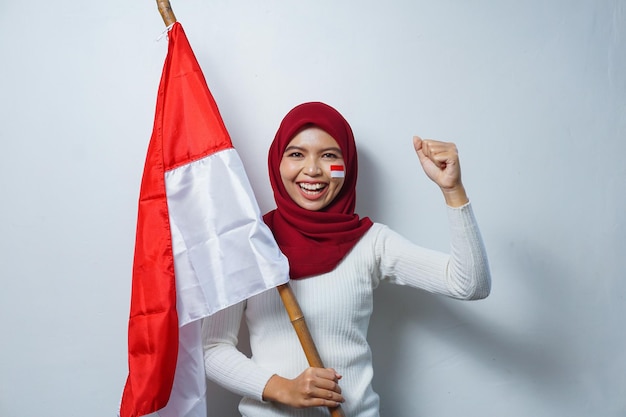 Retrato de mulheres muçulmanas asiáticas comemoram o dia da independência indonésia segurando bandeira vermelha e branca