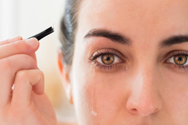 Retrato de olhos de cor amarela chorando depois de arrancar as sobrancelhas