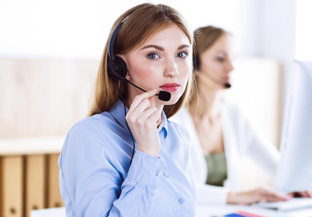 Retrato de operador de call center no trabalho. Grupo de pessoas em um fone de ouvido pronto para ajudar os clientes. Conceito de negócios.