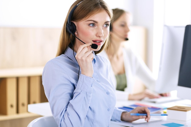 Retrato de operador de call center no trabalho. Grupo de pessoas em um fone de ouvido pronto para ajudar os clientes. Conceito de negócios.