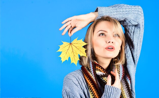 Retrato de outono de mulher de cabelo loiro com folha de plátano. Outono. Humor de outono. Mulher sensual com folha outonal. Folha de bordo amarela. Mulher sexy segura a folha na mão. Copie o espaço.