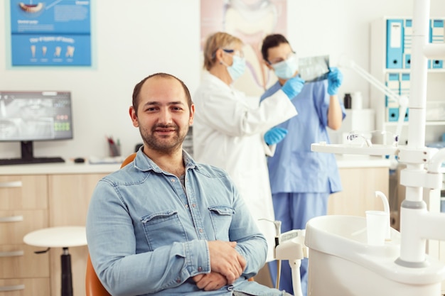 Retrato de paciente homem sentado na cadeira odontológica se preparando para a consulta de estomatologia esperando tratamento de somatologia