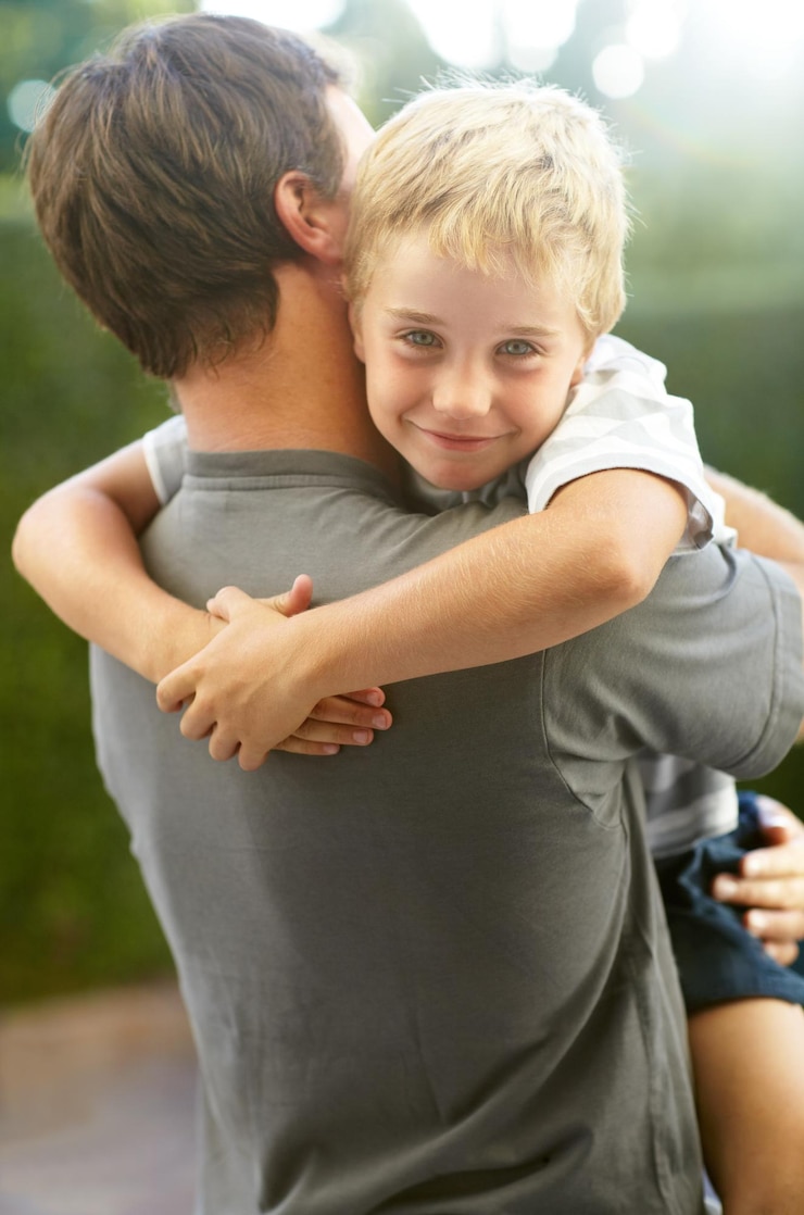 Foto retrato de pai abraçando filho no quintal bonito se unindo em cuidado e amor no jardim apoio de diversão ao ar livre e pai segurando filho brincalhão com sorriso confiança e homem feliz com filho no playground