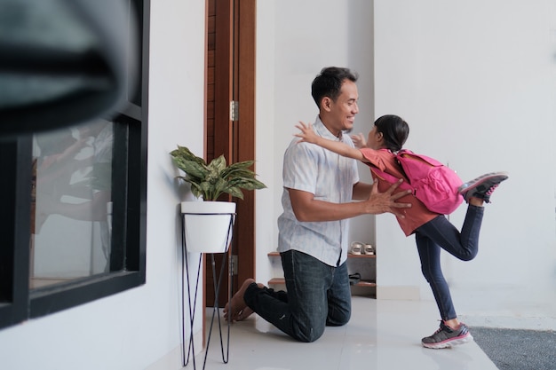 Retrato de pai asiático feliz dando as boas-vindas ao filho após terminar a escola