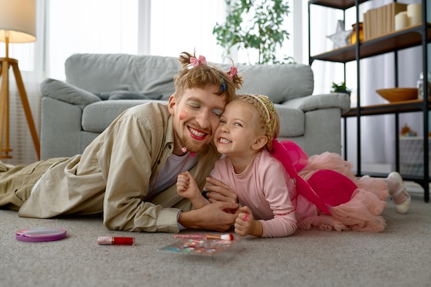 Retrato de pai e filha sorridentes felizes, tempo divertido em família em casa, maquiagem engraçada do papai