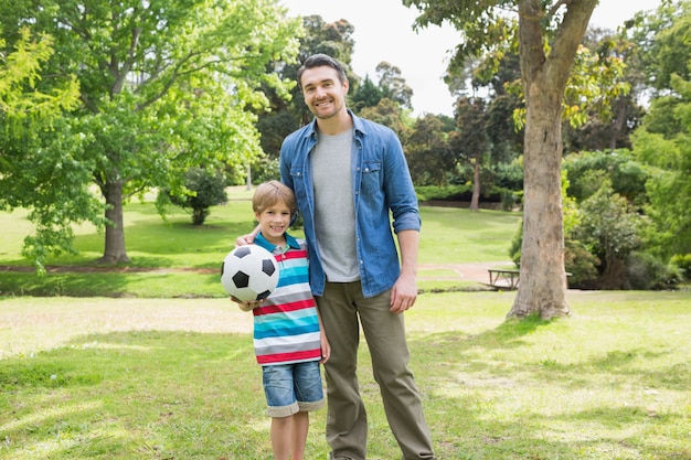 Retrato de pai e filho com bola no parque