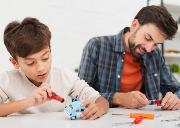 Retrato de pai e filho, consertando carros de brinquedo