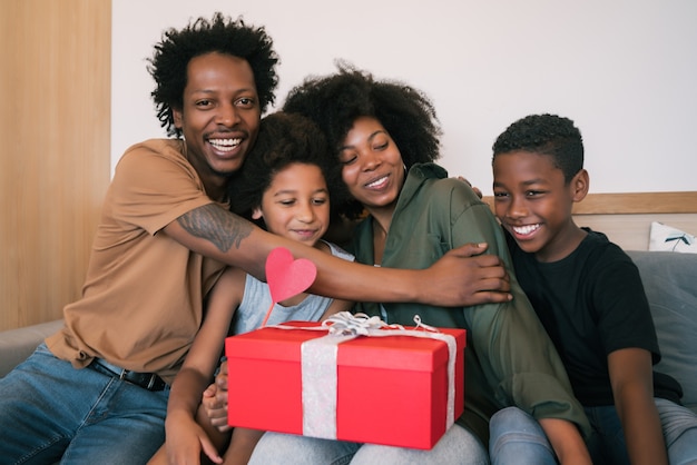 Retrato de pai e filhos parabenizando a mãe no dia das mães e dando presentes a ela em casa