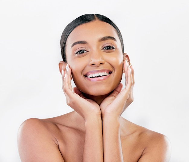 Retrato de pele e rosto de beleza de uma mulher feliz com brilho natural isolado em um fundo branco Maquiagem dermatológica e cosméticos do modelo feminino indiano para brilho facial ou autocuidado em estúdio