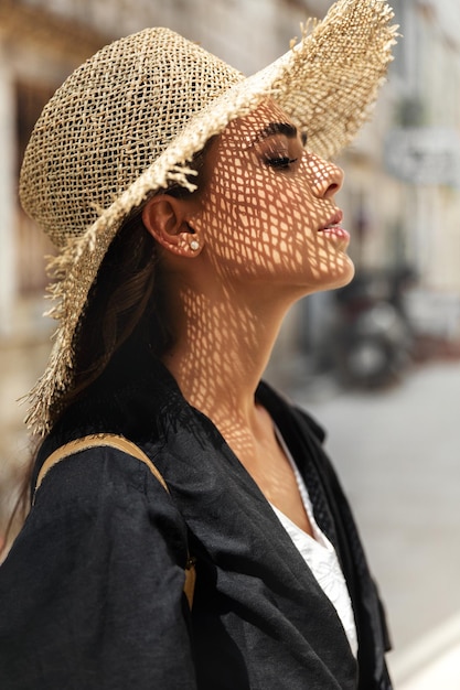 Retrato de perfil de uma linda garota com um chapéu de palha.