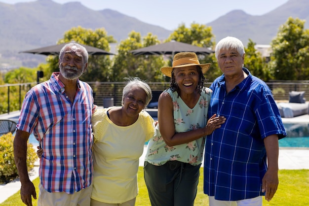 Retrato de pessoas felizes e diversas, abraçando e sorrindo no jardim