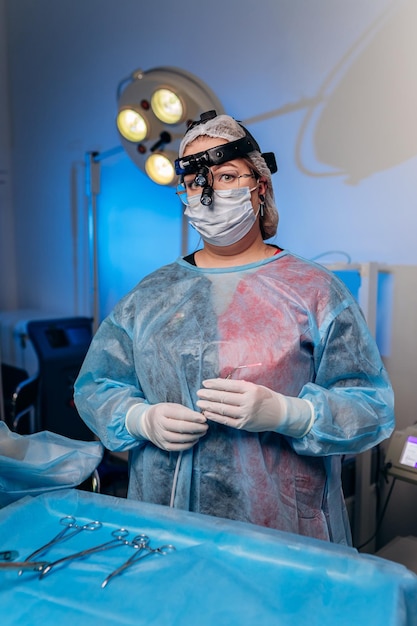 Retrato de proctologista cirurgiã profissional antes da operação segurando um anuscópio na sala de cirurgia do hospital Conceito cirúrgico urgente