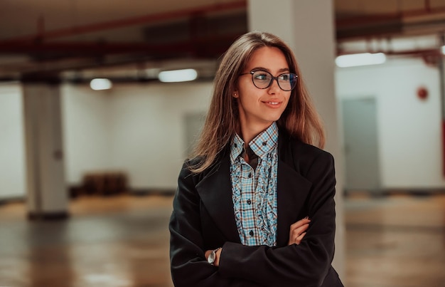 Retrato de profissional feminina de sucesso com os braços cruzados Empresária sorridente em pé na garagem