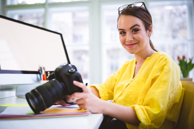 Retrato de profissional feminino confiante com edição de câmera no escritório