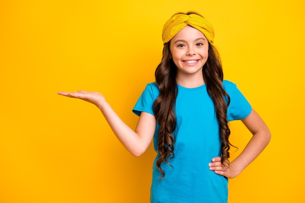 retrato de promotor de menina criança alegre positiva segurar anúncio de exibição de mão