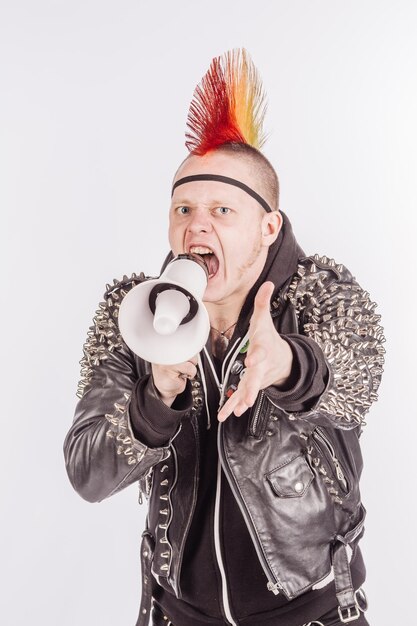 Foto retrato de punk rocker segurando gritando com um megafone contra um fundo branco