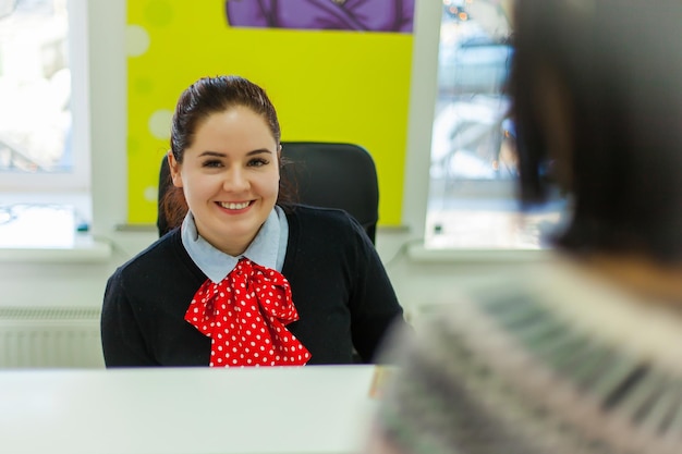 Foto retrato de recepcionista sorridente sentado em um hotel