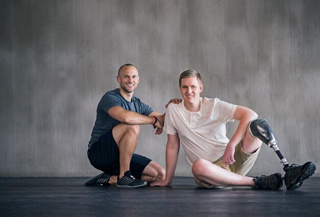 Retrato de recuperação positiva Retrato de um homem amputado e seu fisioterapeuta