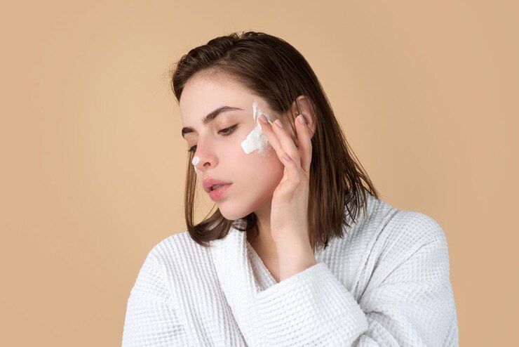 Foto retrato de rosto de beleza de mulher de linda modelo feminina aplicando creme hidratante em seu rosto bonito s