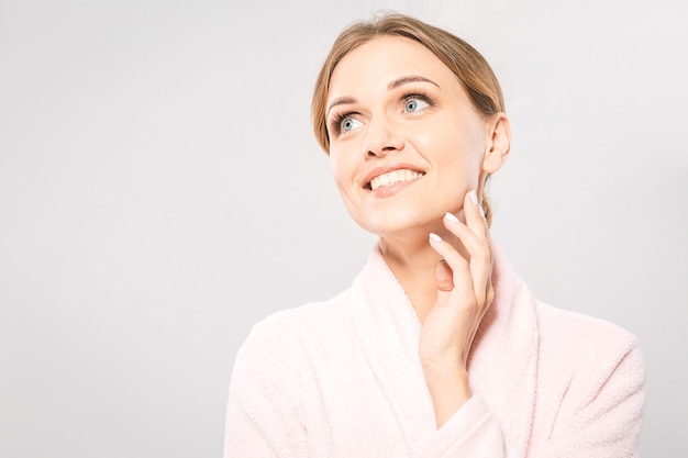 Retrato de rosto de mulher de beleza. Modelo de spa linda garota com pele limpa, fresca perfeita. Mulher loira olhando para cima e sorrindo. Conceito de juventude e cuidados com a pele