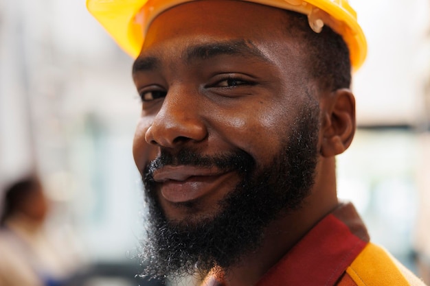 Retrato de rosto sorridente do manipulador de pacotes do armazém afro-americano. Funcionário do armazém da empresa de transporte usando capacete de segurança trabalhando na sala de armazenamento e olhando para a câmera