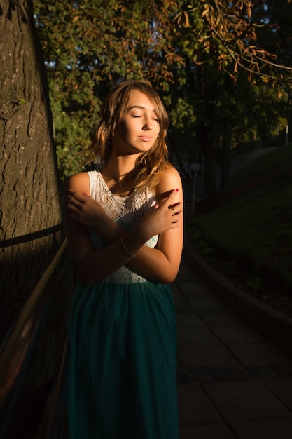 Retrato de rua de modelo sensual com olhos fechados, posando para um dia ensolarado