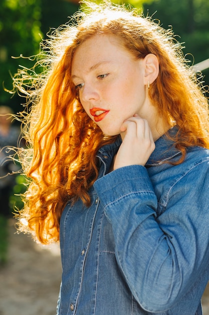 Retrato de rua de uma adorável jovem modelo ruiva com cabelo encaracolado