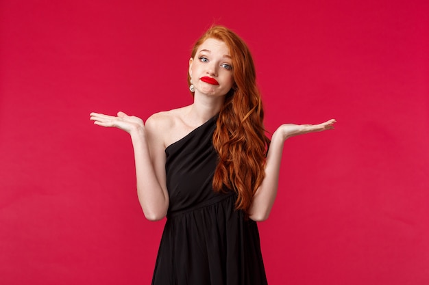 Retrato de ruiva indecisa jovem caucasiana descuidada em elegante vestido preto