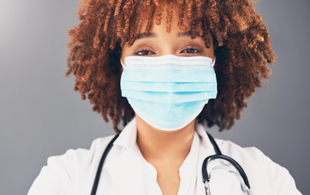 Retrato de saúde e mulher negra com máscara de bem-estar e proteção contra fundo de estúdio cinza Capa facial médica afro-americana e profissional médica com regulamentos de segurança