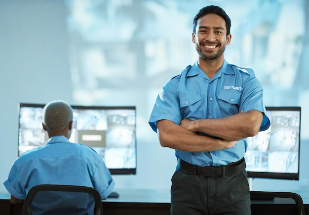 Foto retrato de segurança e homem com sorriso na sala de controle como funcionário da agência com profissional de segurança de rosto asiático e trabalhando no centro de dados para vigilância de crime em vídeo com tecnologia