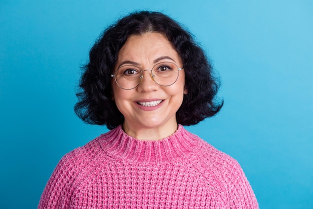 Retrato de senhora idosa sorrindo em óculos suéter de pescoço polo usando lente de óculos rosa isolado fundo de cor azul