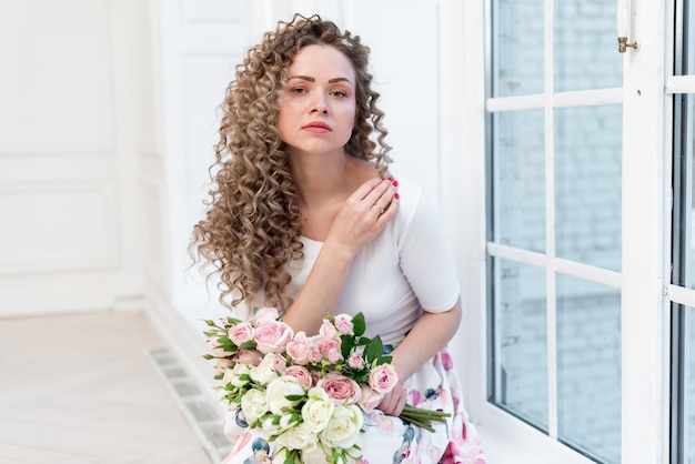 Retrato, de, sensual, loiro, menina curly, senta-se, logo, a, janela, e, segura, um, buquê rosas