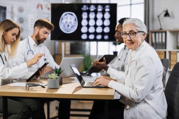 Foto retrato de séria médica madura com laptop